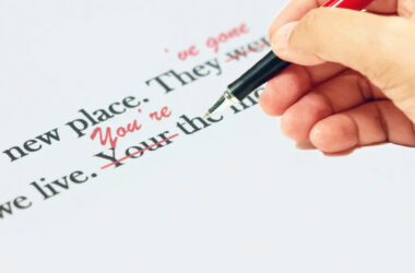 proofreading of English sentences on white paperwork with hand holding pen